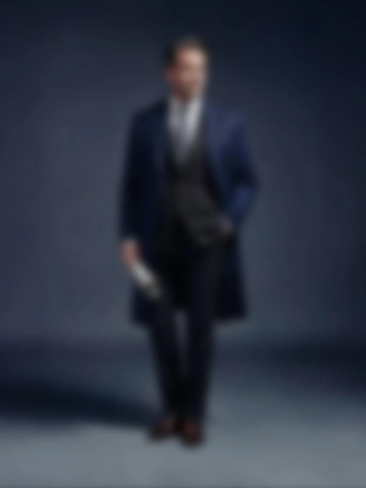 Ein verschwommenes Bild einer Person in formeller Kleidung, die auf einer Bühne steht.