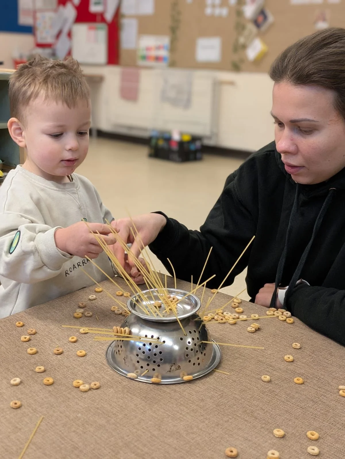 Nursery practitioner helping toddler with sensory play activity at Pop-Up Nursery Wellingborough