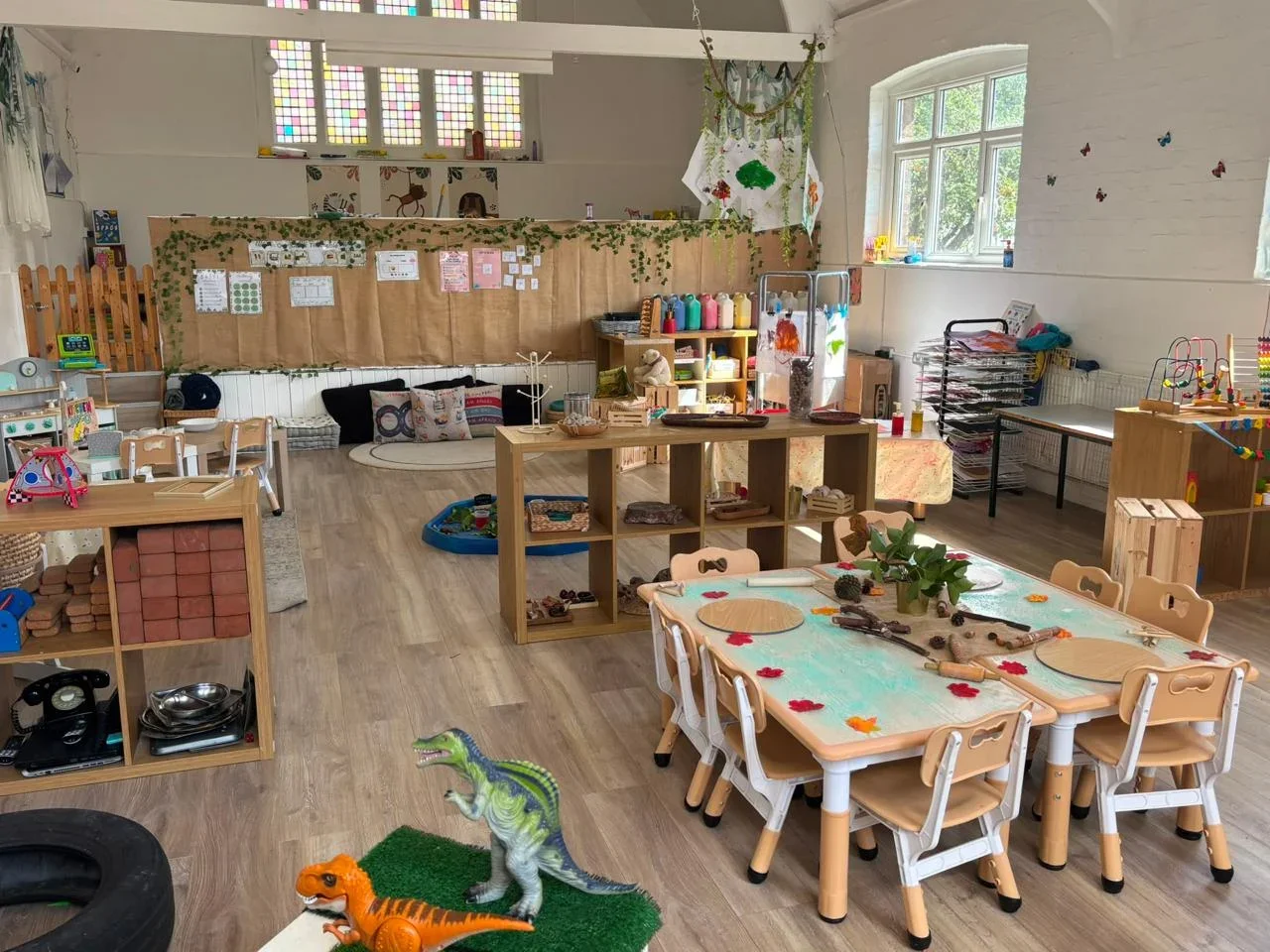 Bright playroom at Pop-Up Nurseries with child-sized tables, natural play materials and nature-themed displays