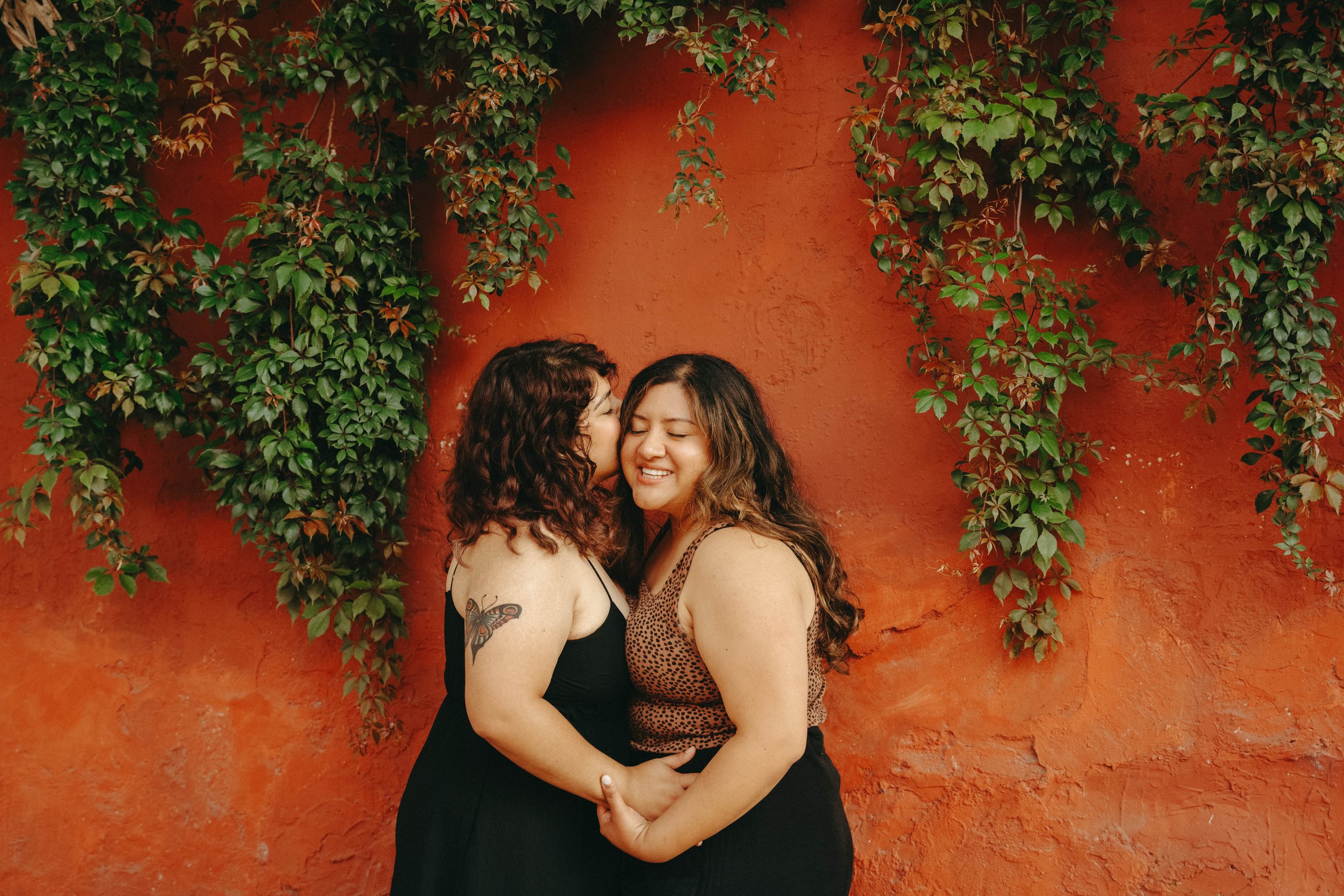 Lesbian couple posing in the beautiful walls of Antigua Guatemala for a very romanatic and authentic portrait session  (part of Diana Alvarado’s lifestyle and LGBTQ+ couple photography in Guatemala).