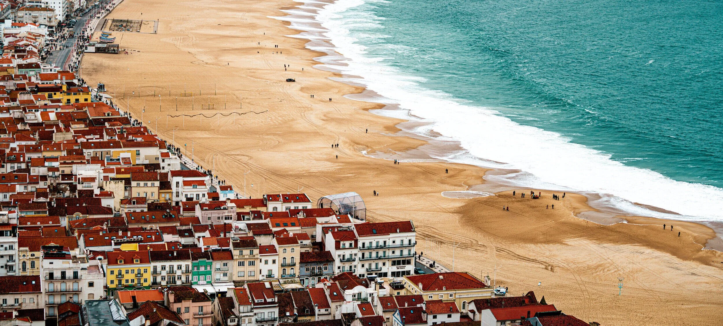 Pause of The Atlantic — vista elevada da praia e do casario de Nazaré, Portugal