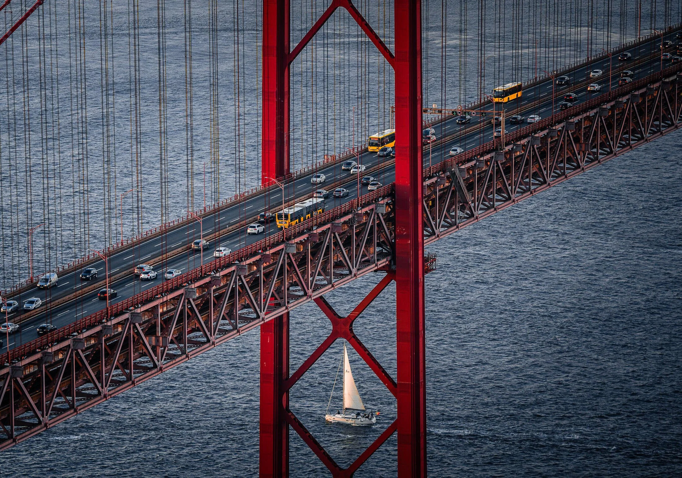 Travessia Silenciosa — Ponte 25 de Abril, Lisboa, com veleiro emoldurado pela estrutura