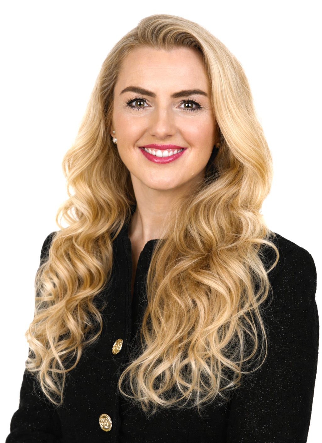 Eine lächelnde blonde Frau mit lockigem Haar in einem schwarzen Kleid mit goldenen Knöpfen.