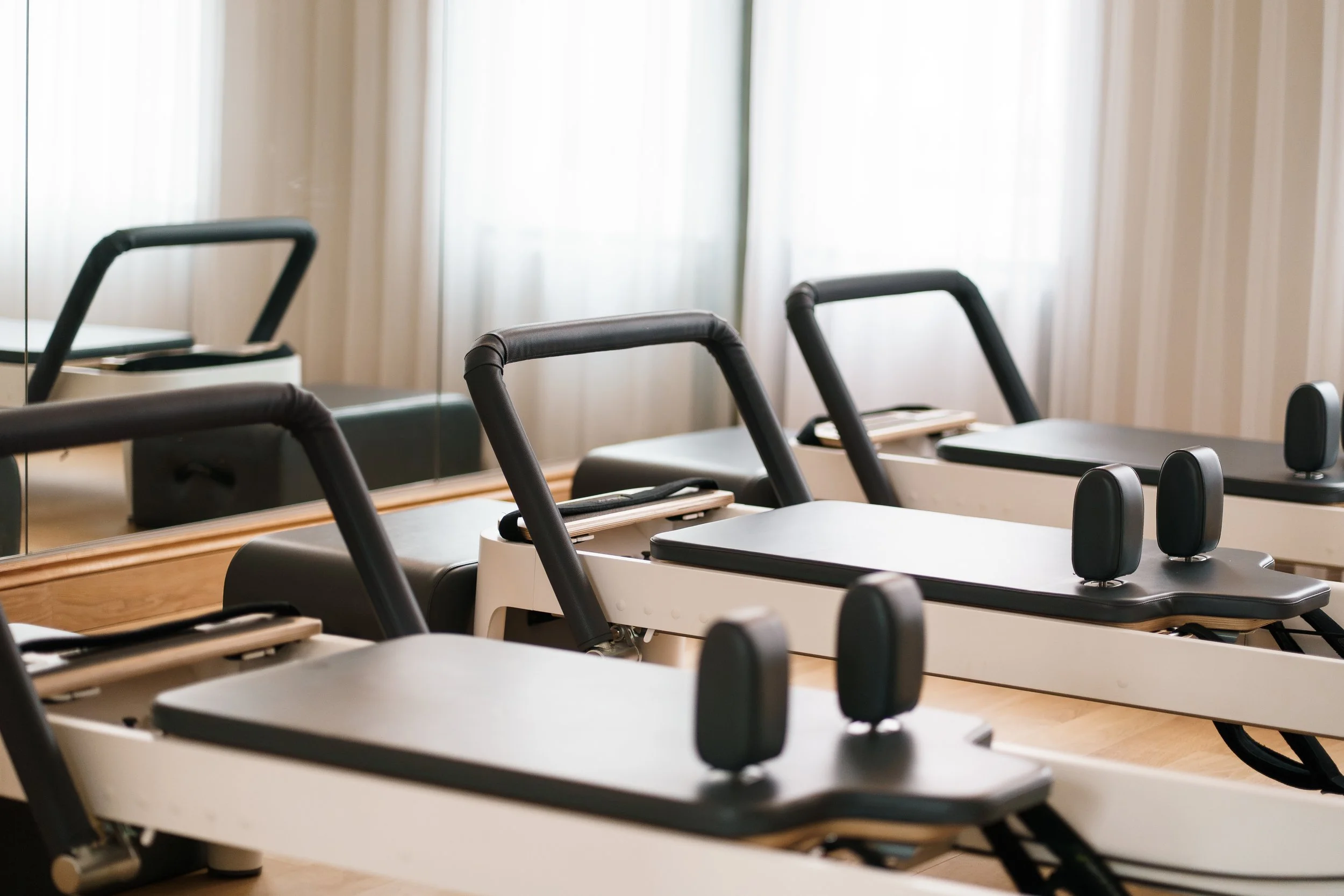 Rehab or physical therapy chairs with handles and head support in a bright room.