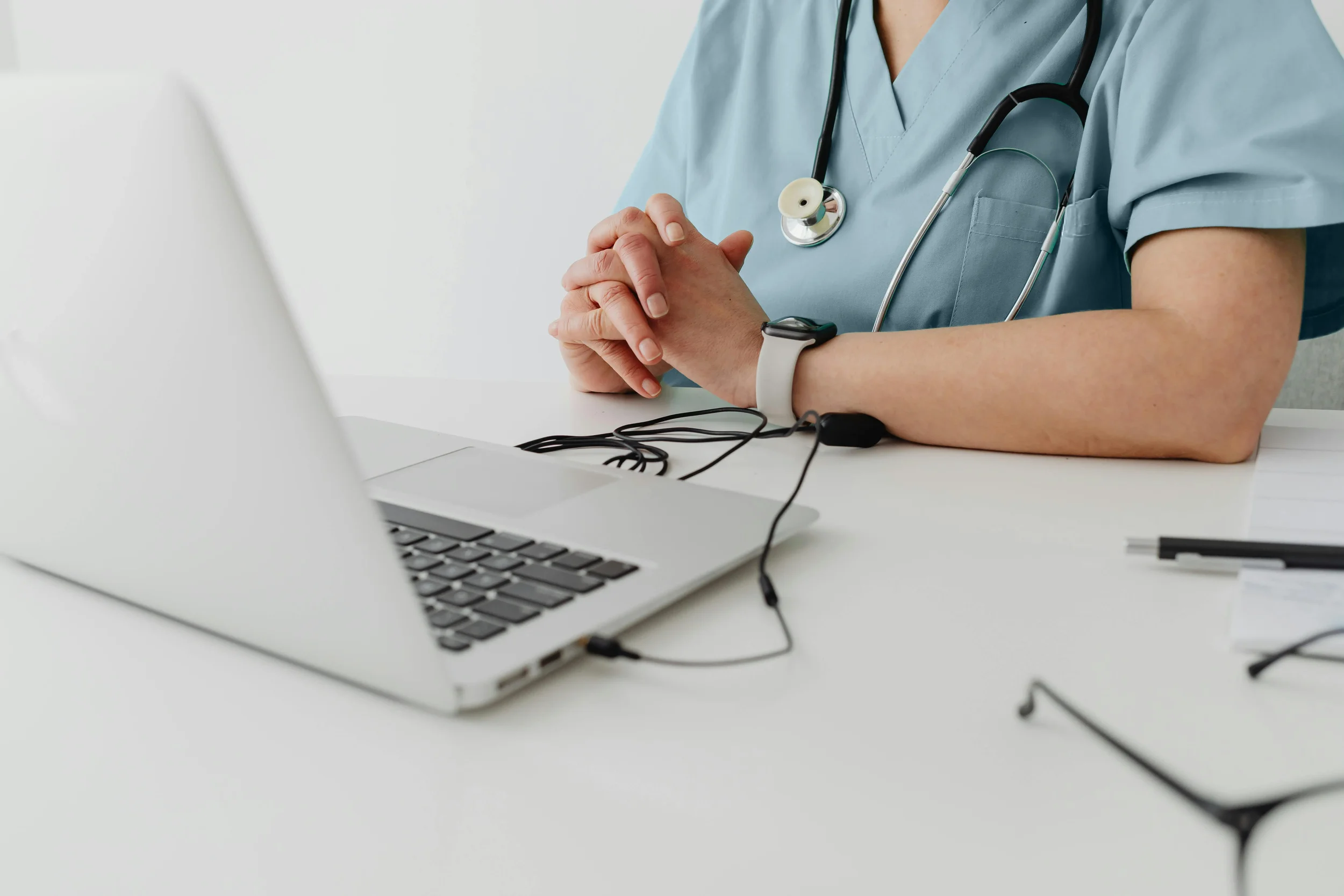Healthcare professional reviewing patient information on a laptop in a clinical setting