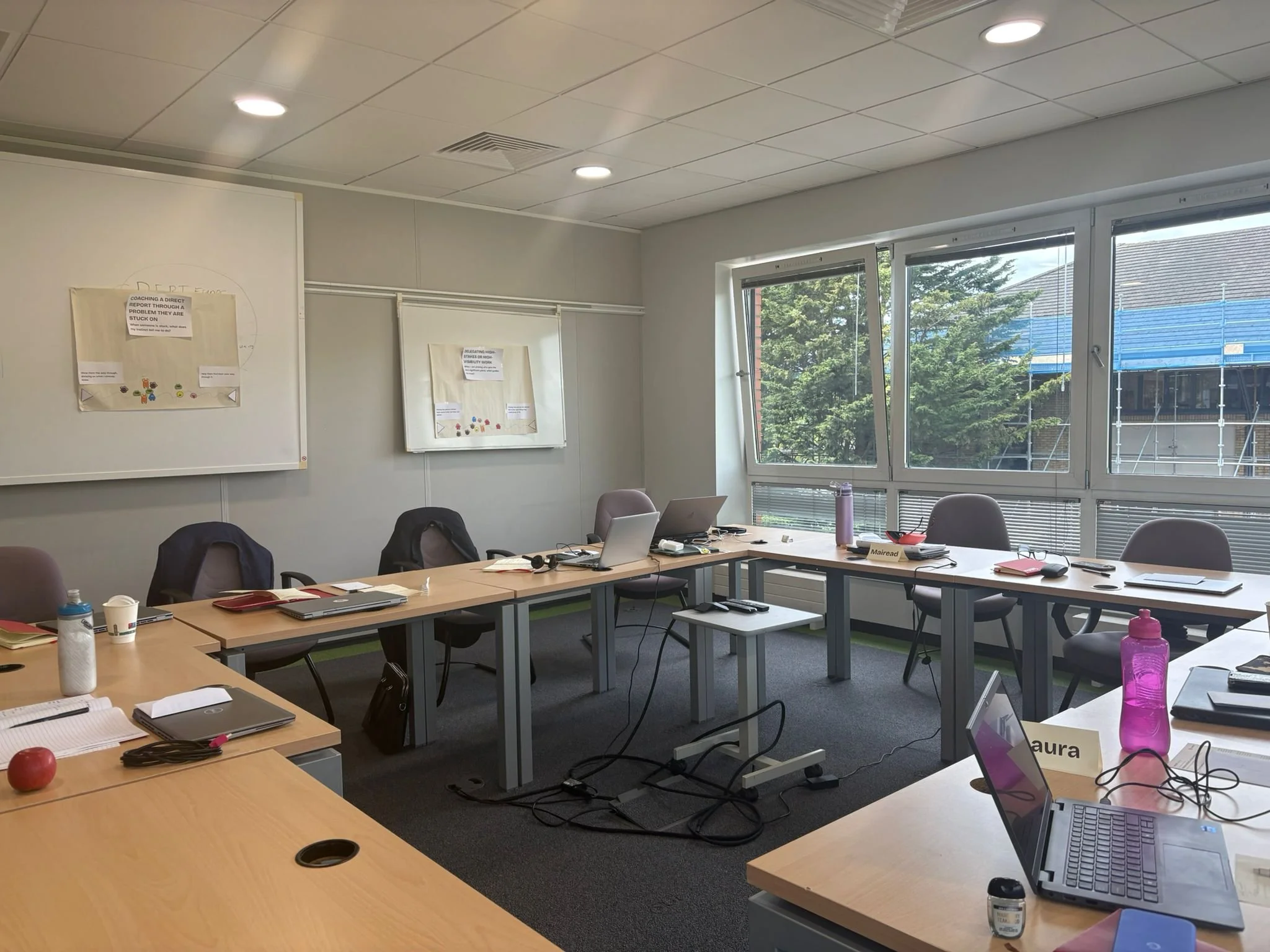 Meeting room epty of people but littered with evidence of a workshop in process