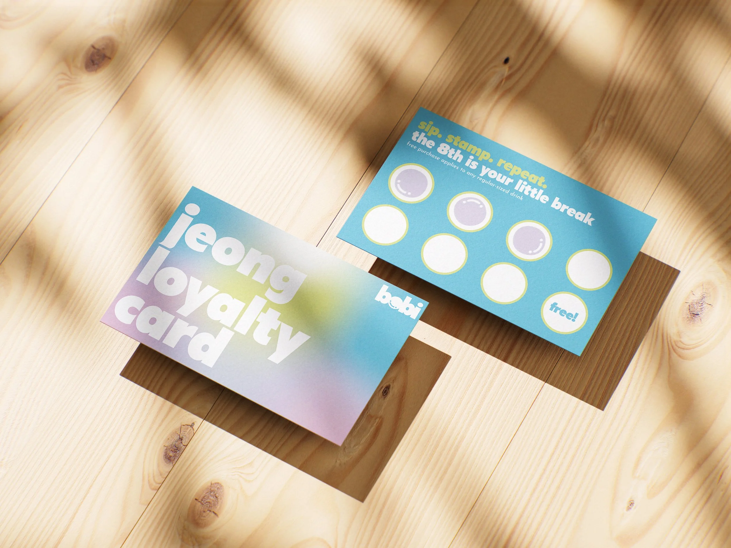 Colorful loyalty card and a punch card on a wooden surface.