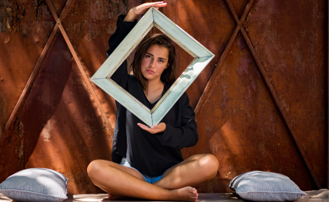 woman holding frame over her face