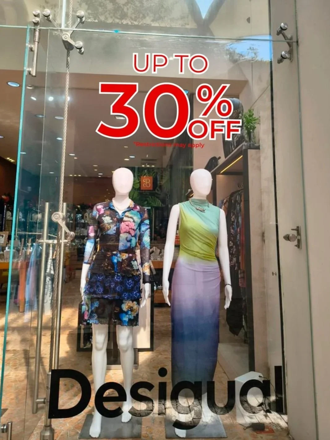 Cartel en una tienda que anuncia descuentos de hasta el 30%.