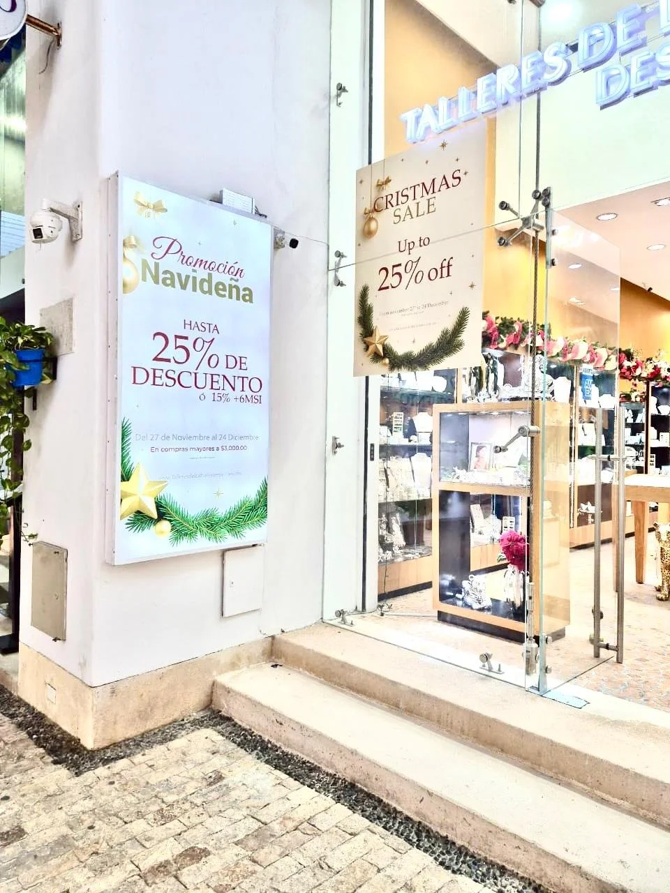 Cartel y cartelera de promoción navideña en una tienda con descuentos de hasta 25% en artículos, decoraciones navideñas y anuncios de venta de Navidad.