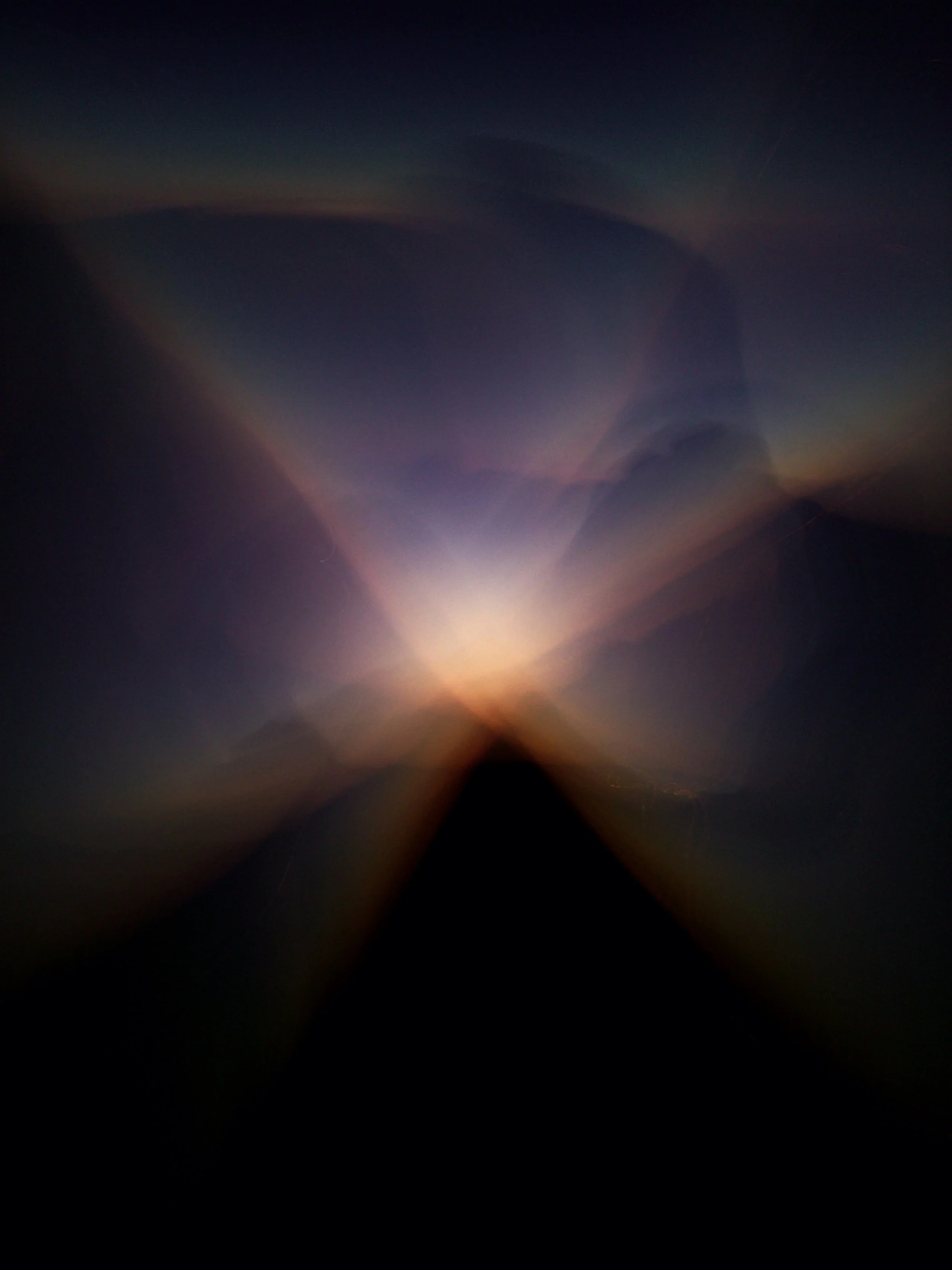 Dark sky with a rainbow mirror-like reflection and a bright light source at the bottom center.