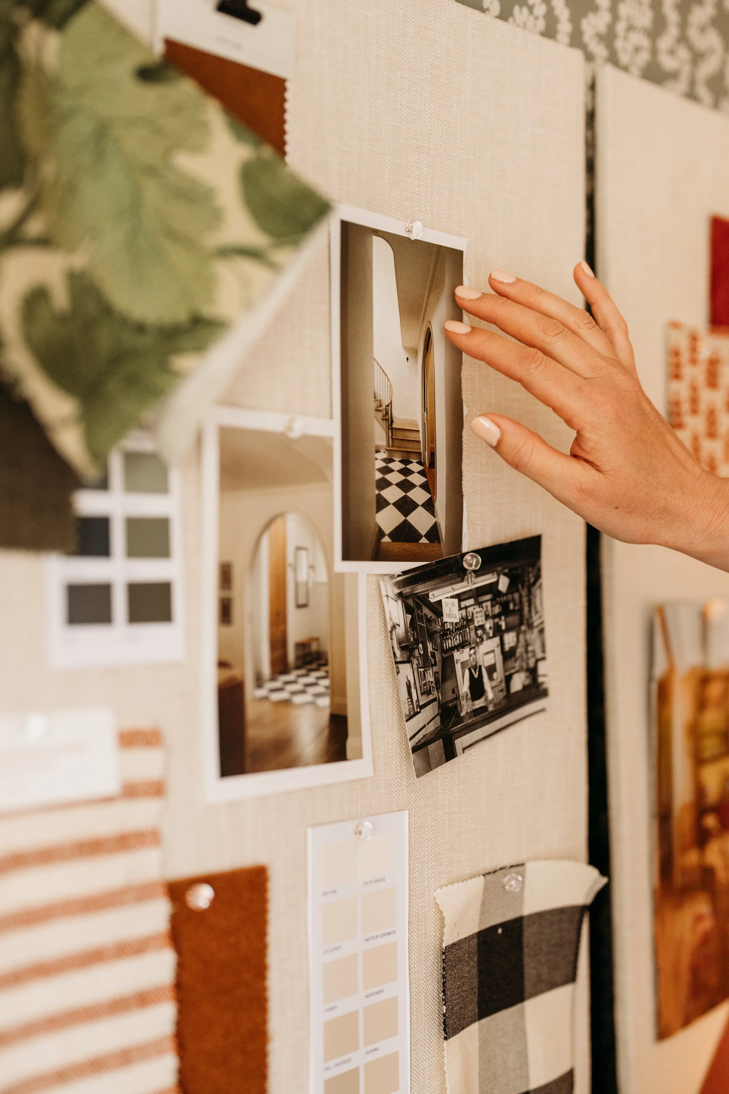 Interior design mood board with photos, fabric swatches, and color palette samples pinned on a linen pin board.