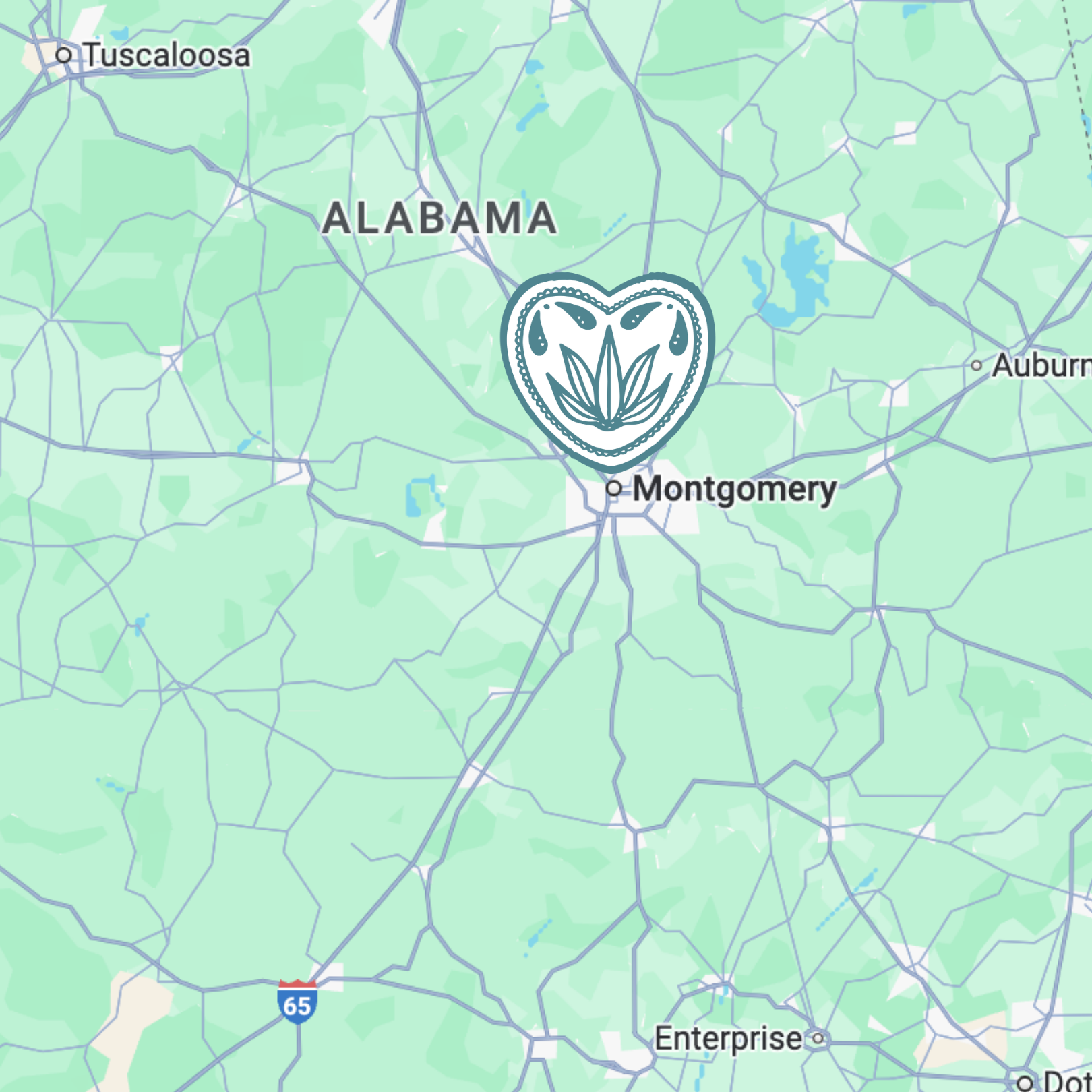 Map showing the area around Montgomery, Alabama, with a decorative heart-shaped outline featuring a floral motif overlapping the map near Montgomery.