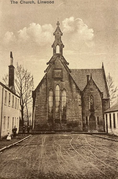 An old black-and-white photograph of the Church in Linwood, showing a large stone church with tall arched windows and a steeple, flanked by residential buildings, with a dirt street in front.