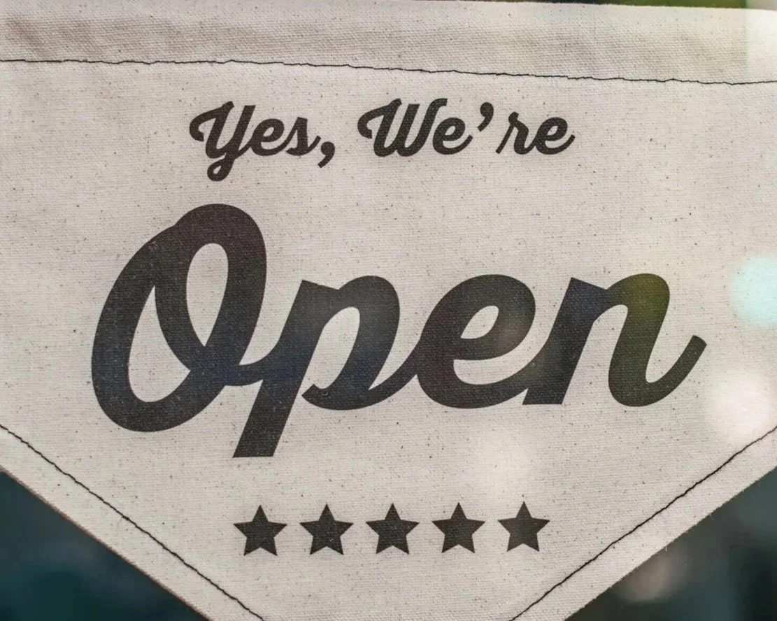 Sign with the text 'Yes, We're Open' and five stars underneath.