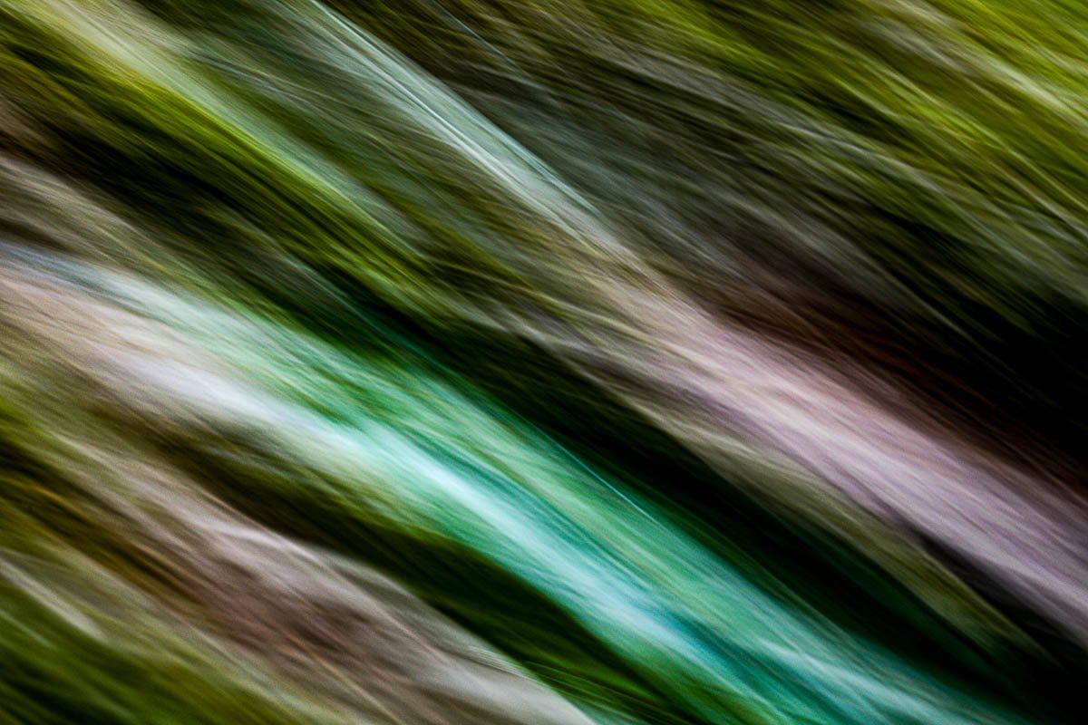 Blurred motion of green, brown, and white streaks in diagonal lines.