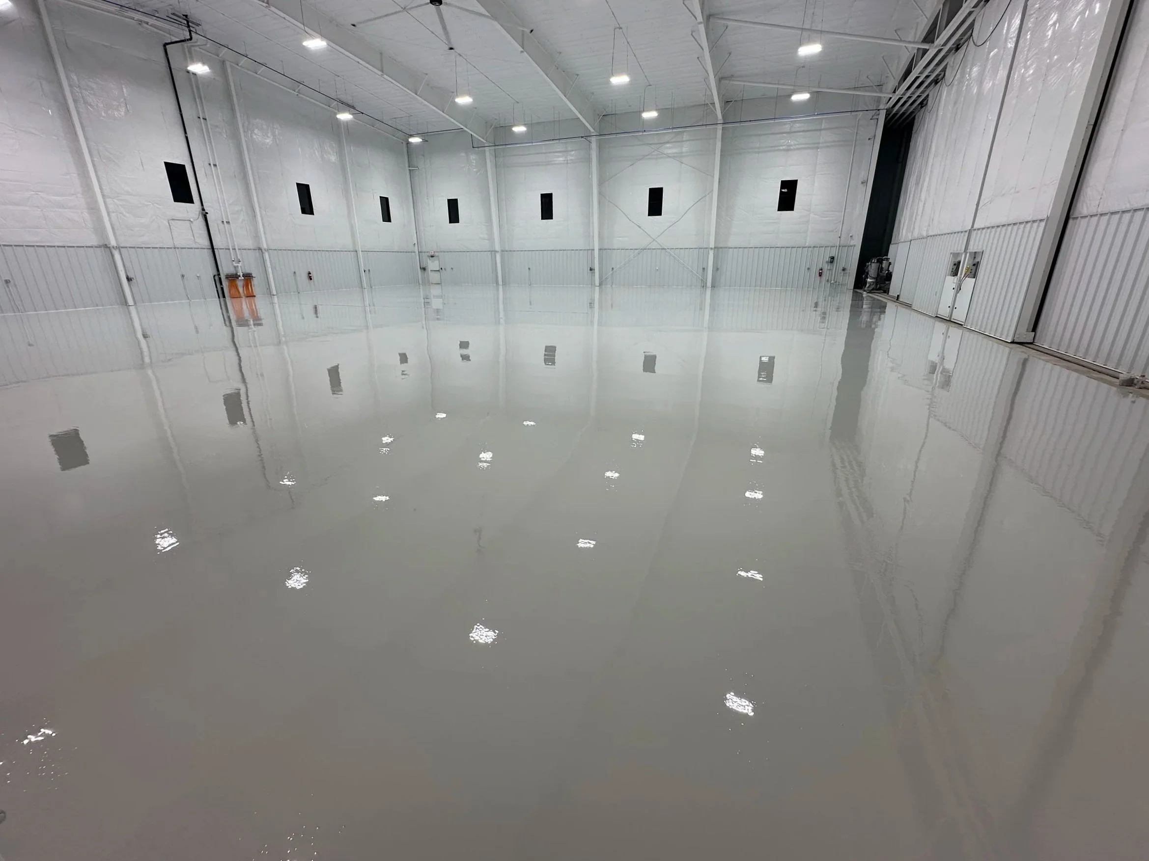 Polished epoxy or grind and seal floor in large Kansas City warehouse with overhead lights