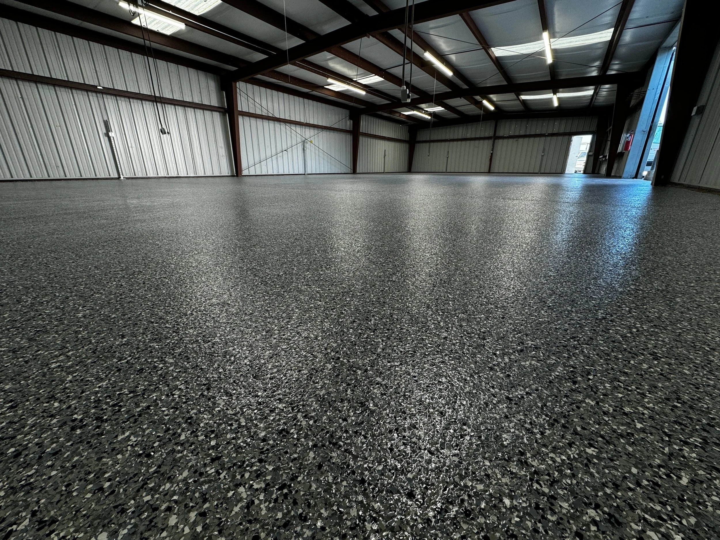 Flake epoxy floor in Kansas City warehouse with industrial finish by Precision KC Coatings