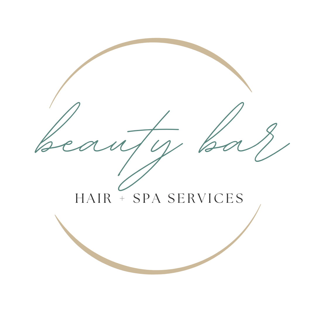 Logo for a beauty bar with a black background, featuring cursive text that says 'beauty bar' within a partial circle, and smaller text below that reads 'HAIR + SPA SERVICES'.