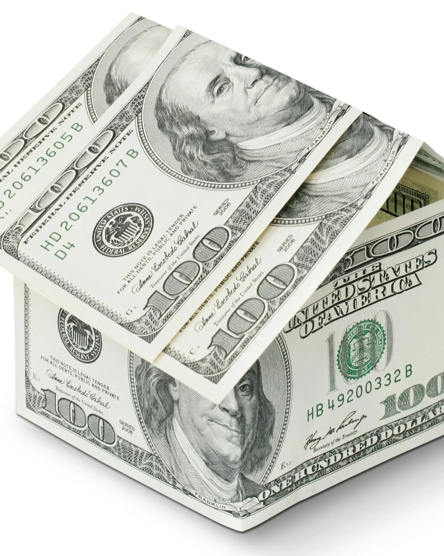 A box made of hundred dollar bills shaped like a house, with one bill partly open inside.