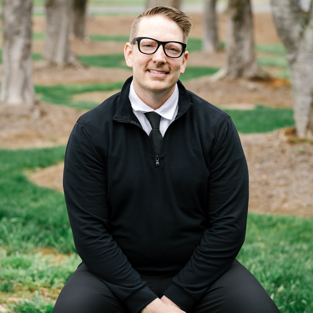 Max Eckerson, licensed counselor at Restore Hope Counseling, seated outdoors in Charlotte, NC
