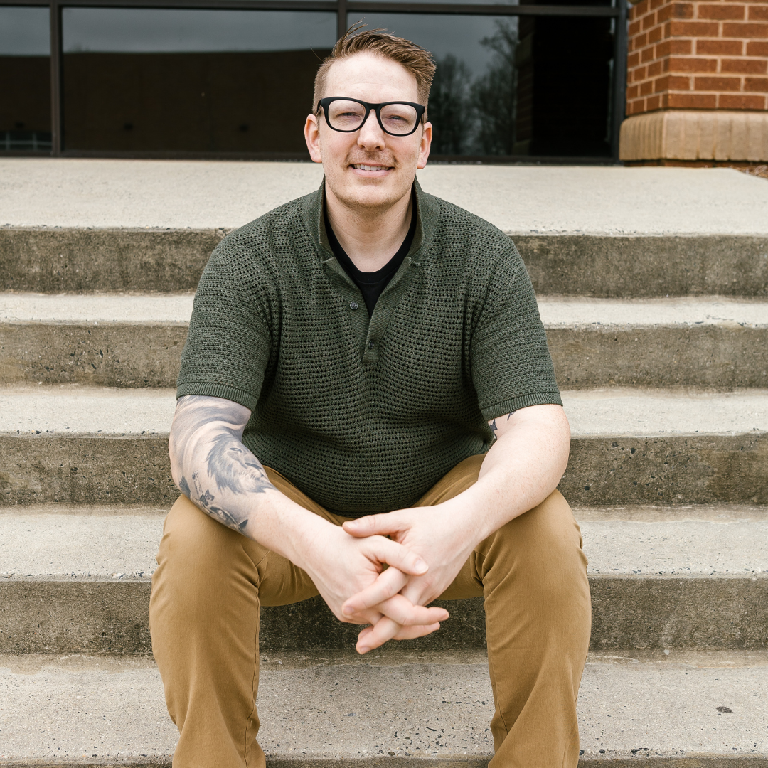 Max Eckerson, men's therapist serving Matthews and Charlotte, NC, seated on building steps