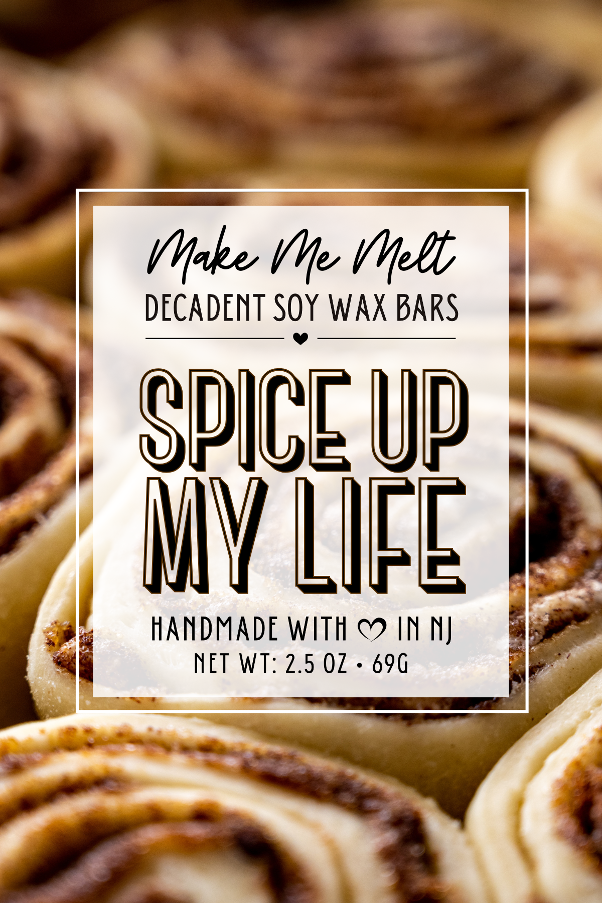 Close-up of a label on a package of spice up my life decadent soy wax bars, with blurred cinnamon roll pastries in the background.