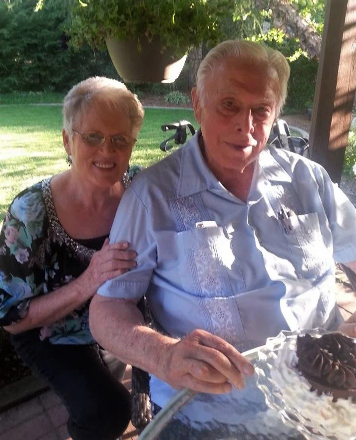 An open Bible with a sprig of small white flowers resting on it.