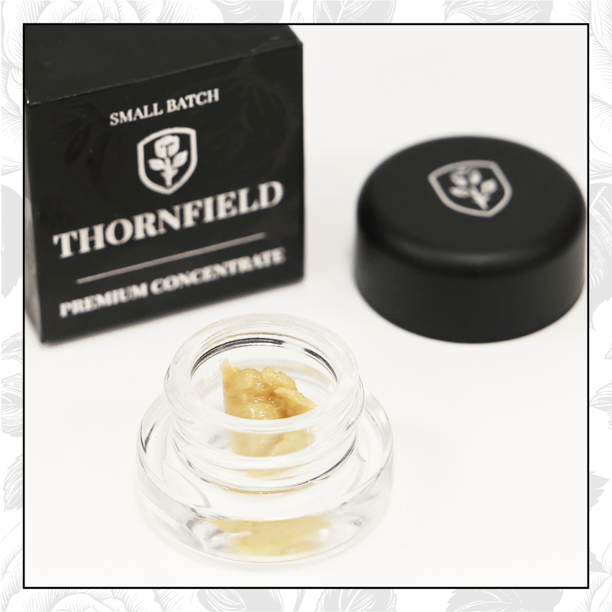 A small jar of wax with a yellowish color, a black container with a lid, and a black box labeled 'Thornfield Small Batch Premium Concentrate'.