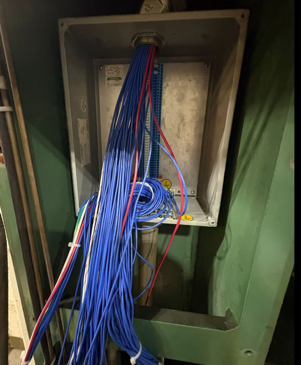 Electrical box with blue, red, yellow, and white wires coming out.