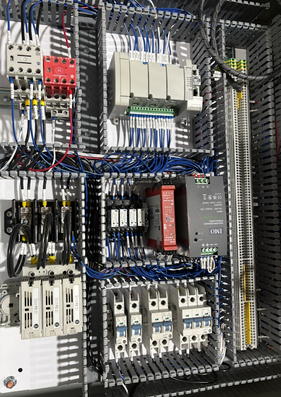 Electrical control panel with various circuit breakers, relays, and wiring.