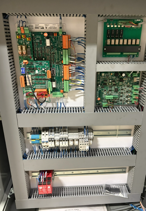 Electrical control panel with circuit boards, relays, and wiring for industrial automation.