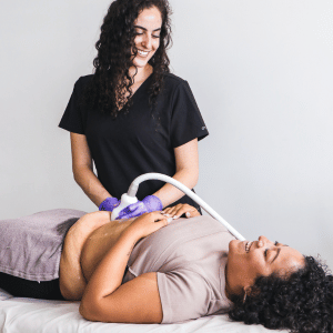 A woman receiving ultrasound treatment from a healthcare professional.