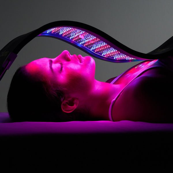 A woman lying down under a UV light therapy device