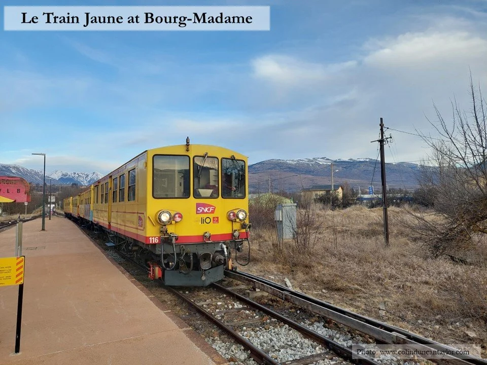 A locomotive of a service called Le Train Jaune arrives in the station at Bourg-Madame.