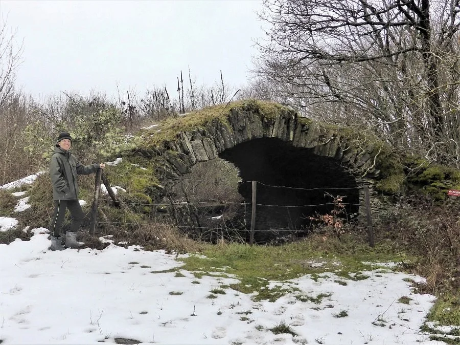 Author Colin Duncan Taylor inspects a ruined ice house near Pradelles-Cabardes.