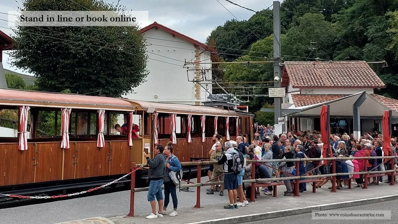 Tourists queue to board the mountain railway to the top of La Rhune.