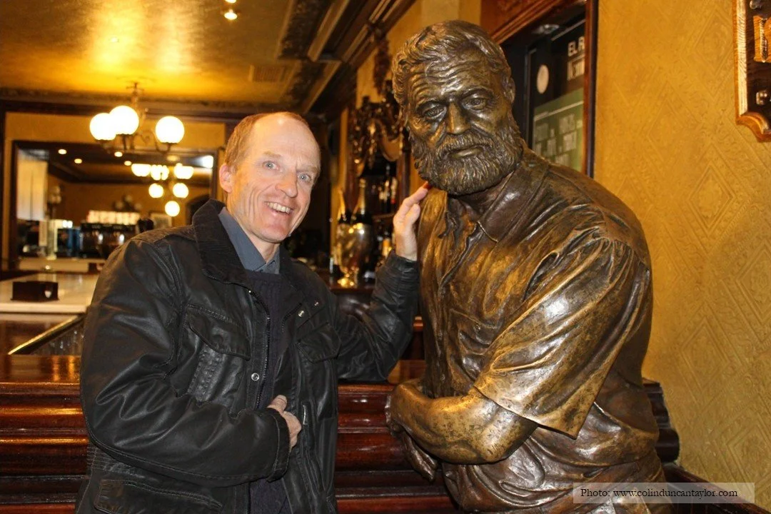 Author Colin Duncan Taylor with Hemingway's statue inside the Cafe Iruña, Pamplona.