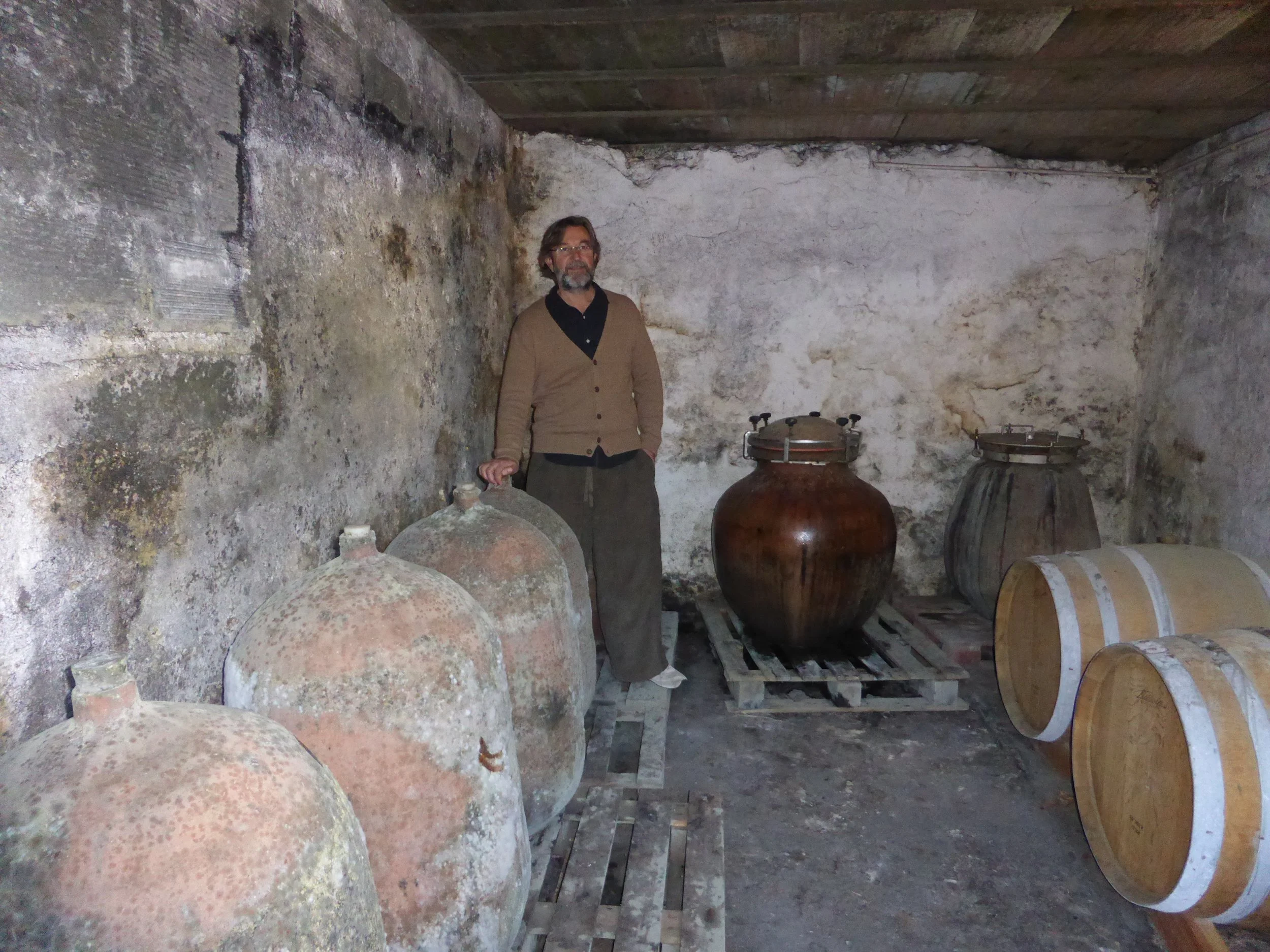 Gilles Contrepois of the Domaine Grand Guilhem in his cellar with clay pots used in his winemaking.