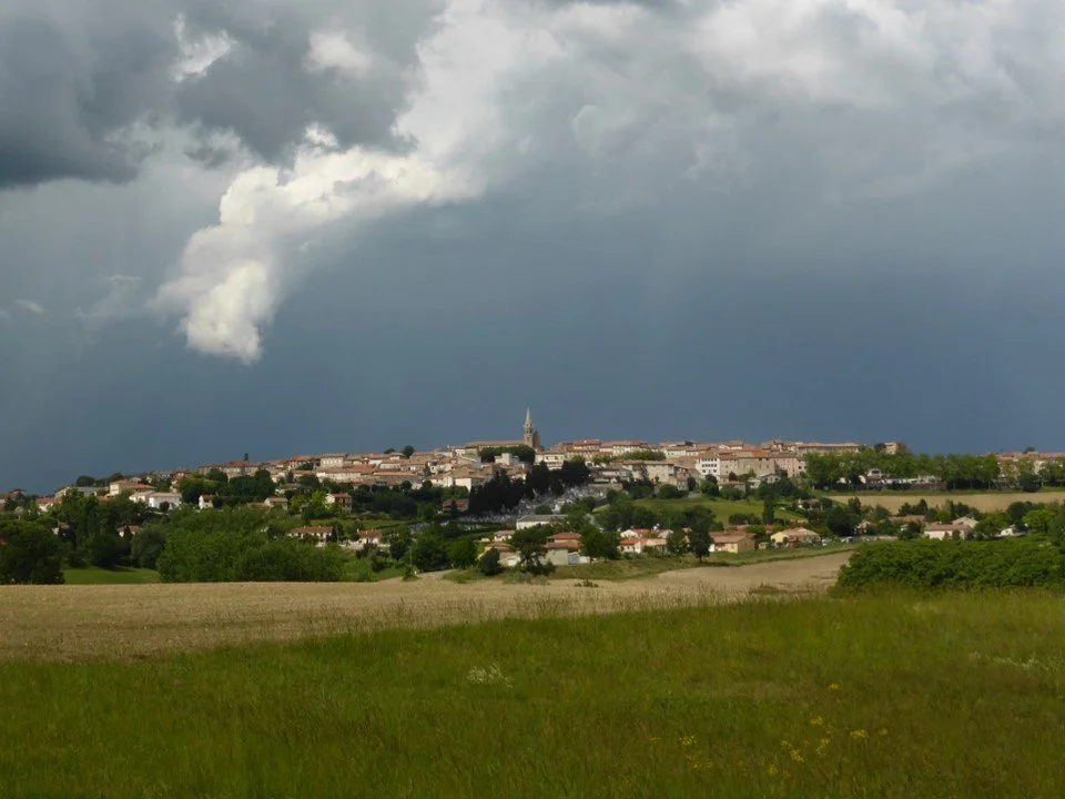 The town of Puylaurens beneath a stormy sky.