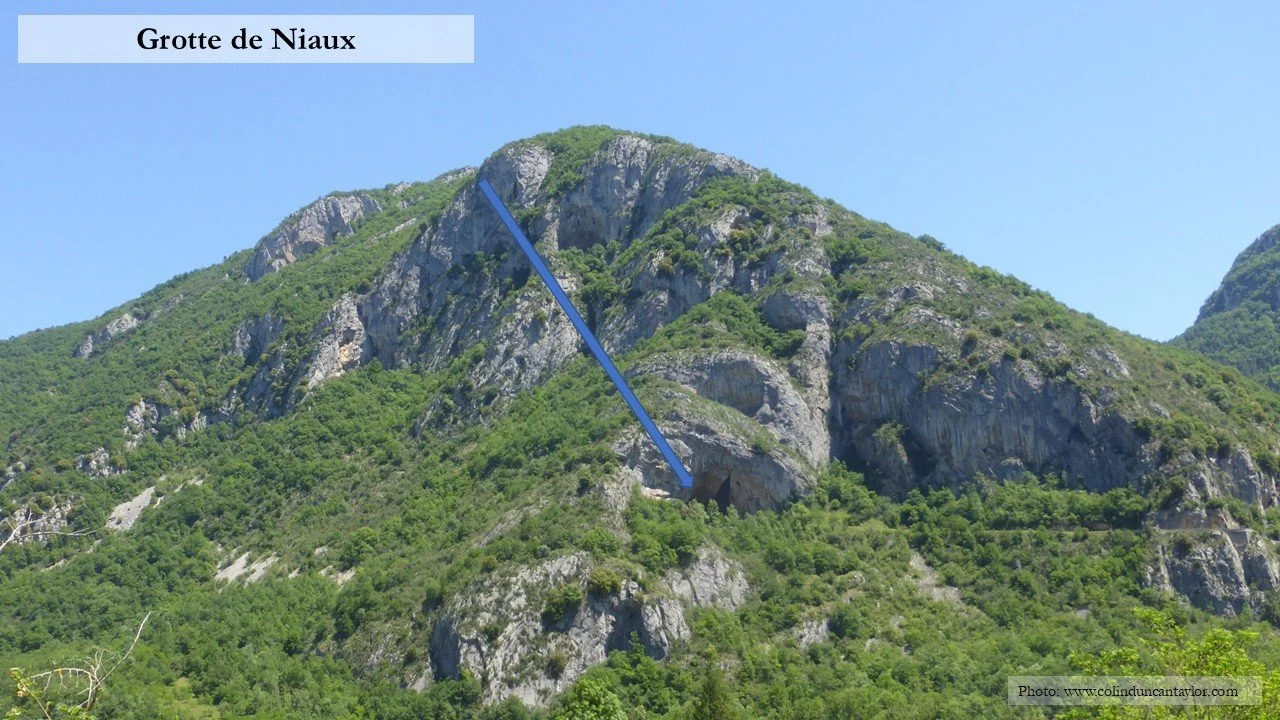 A blue arrow points towards the main entrance of the Grotte de Niaux.