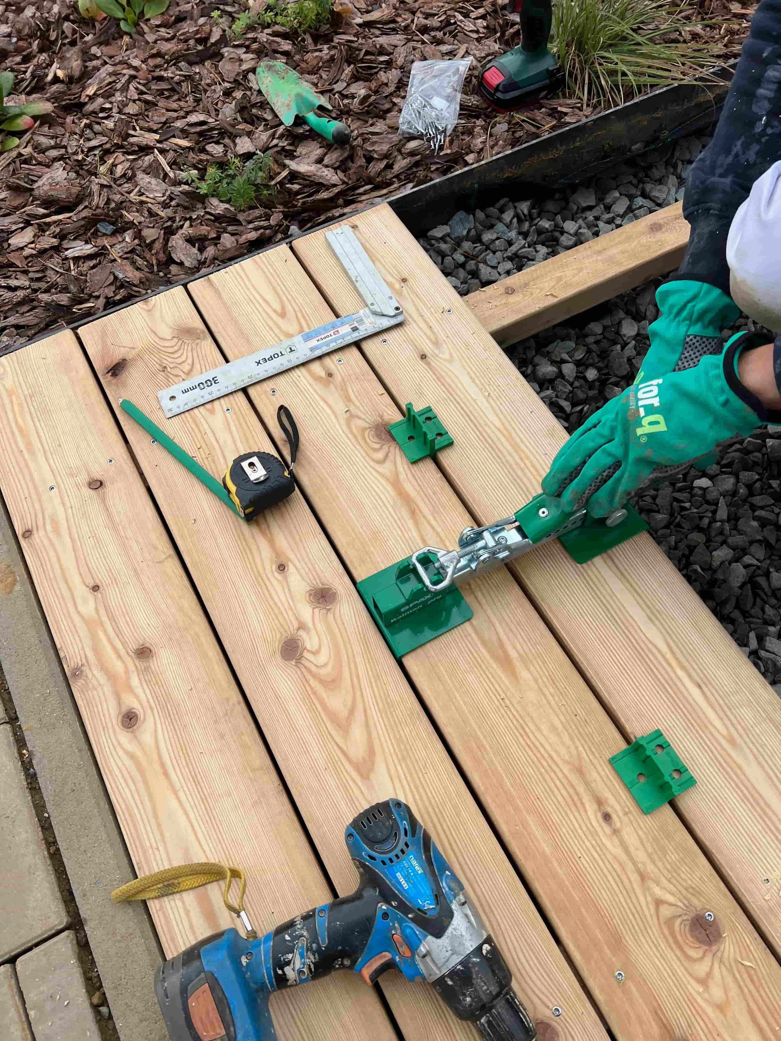 Práce na dřevěné terase – montáž terasových prken pomocí aku vrtačky a ručního nářadí.