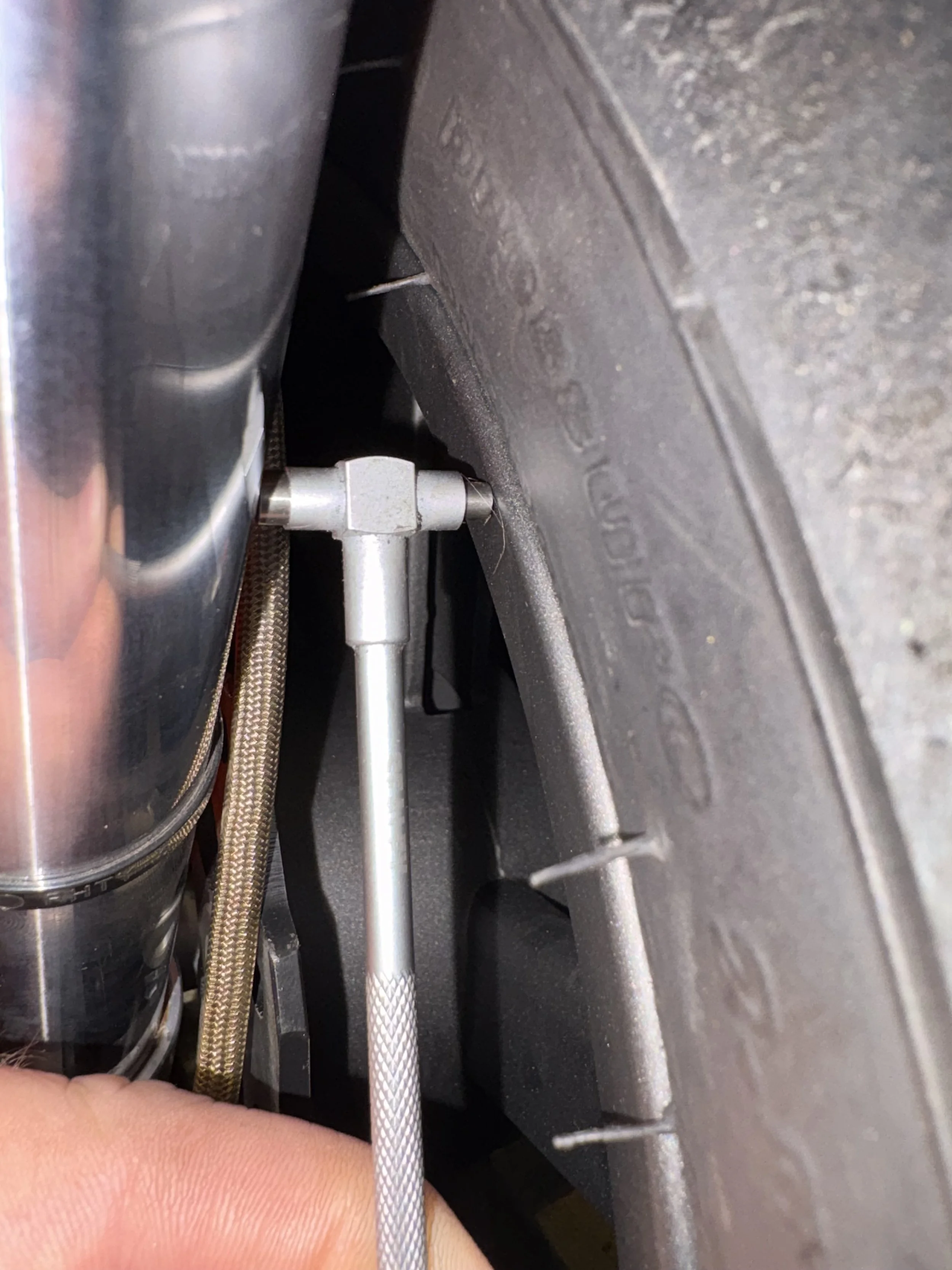 Checking supermoto wheel alignment with a telescoping gauge to ensure accurate wheel offset and optimum handling