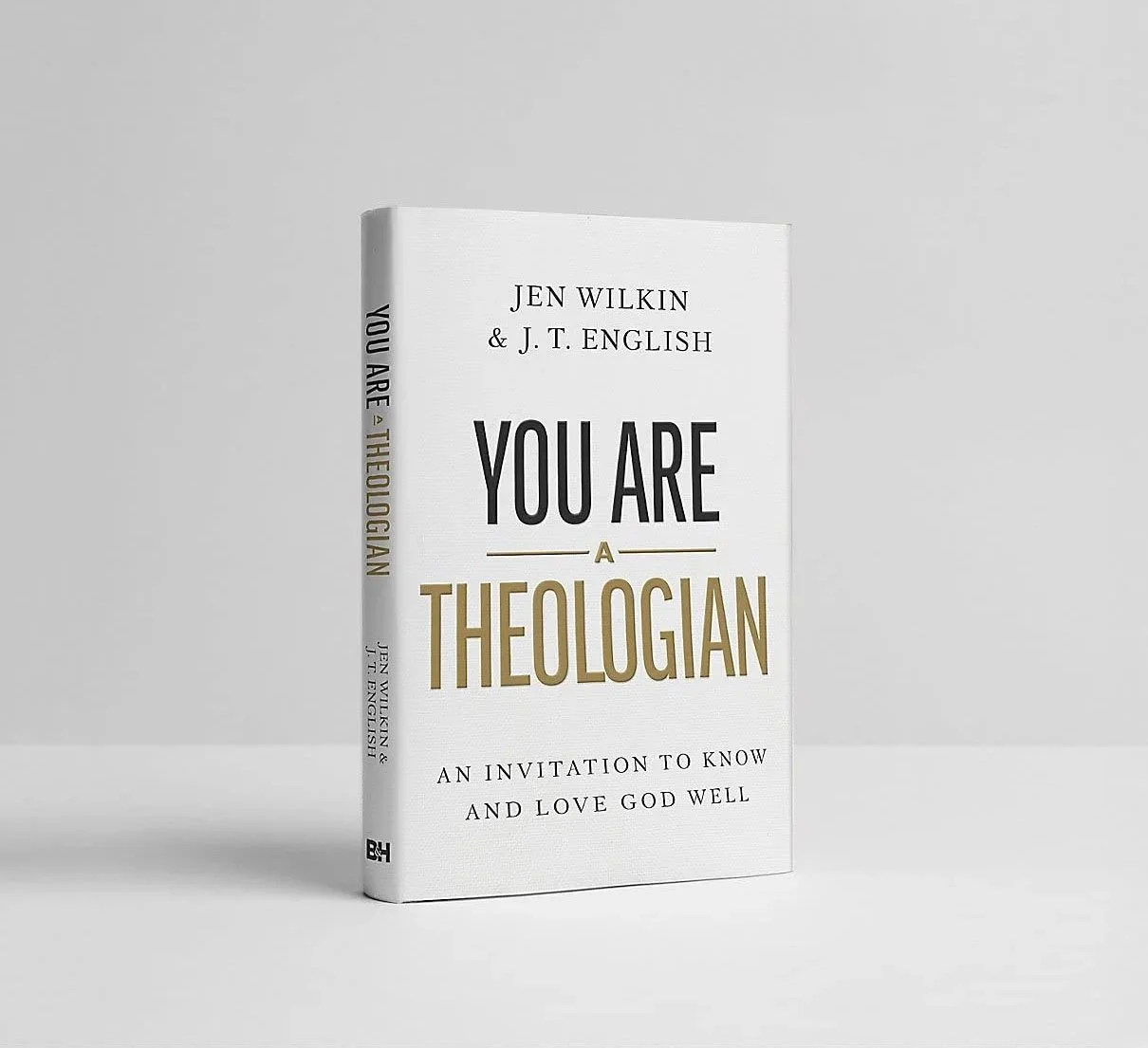 Book titled 'You Are a Theologian' by Jen Wilkin and J. T. English, standing upright on a light grey surface against a light grey background.
