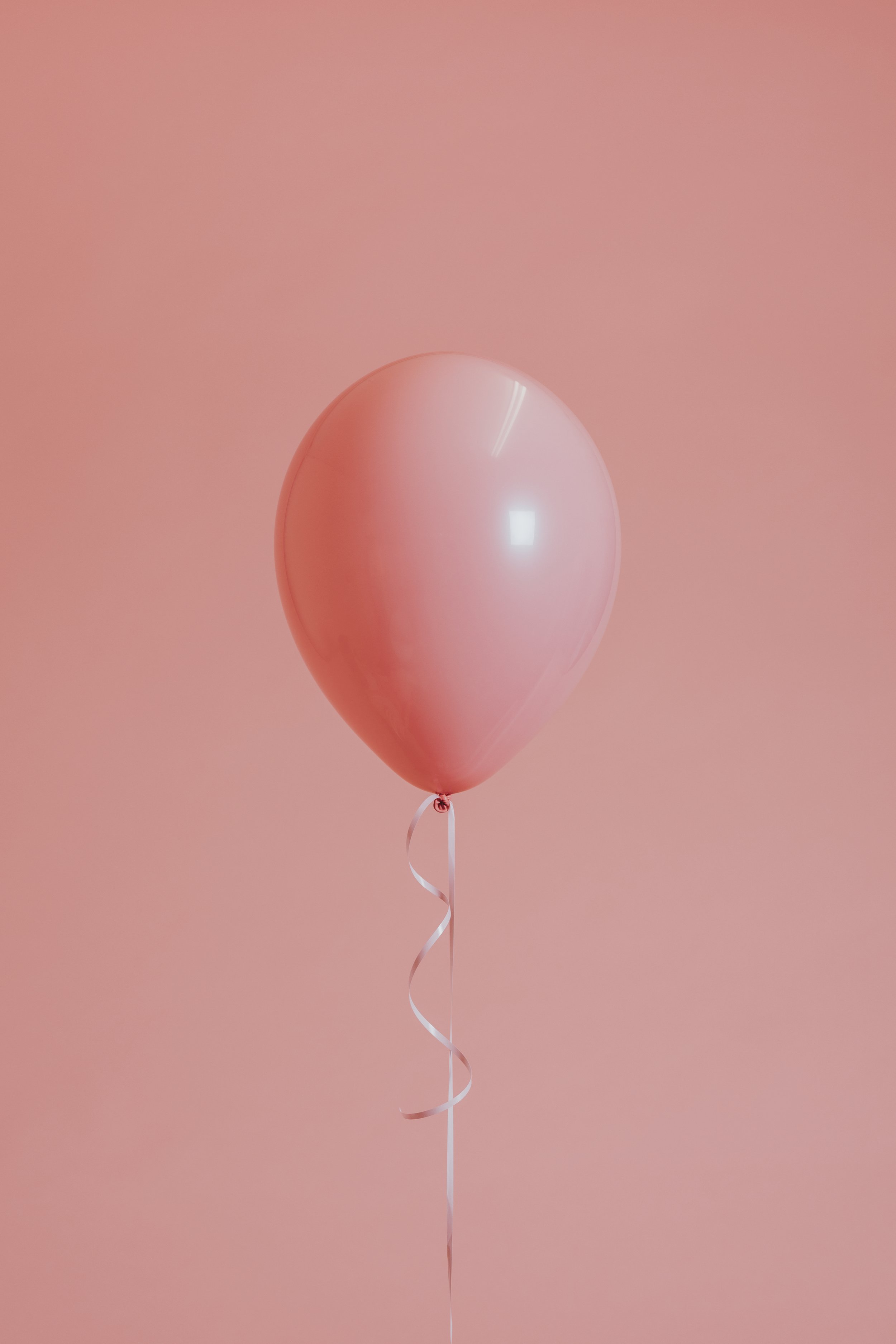 Das Siebdruckatelier Wuschka in Saarbrücken bietet auch Kindergeburtstage an. Ein rosa Heliumballon vor einem gleichen rosa Hintergrund.
