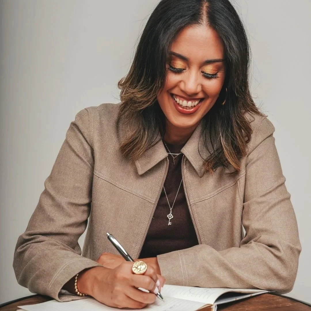 Autora Diane Vázquez escribiendo en una libreta.