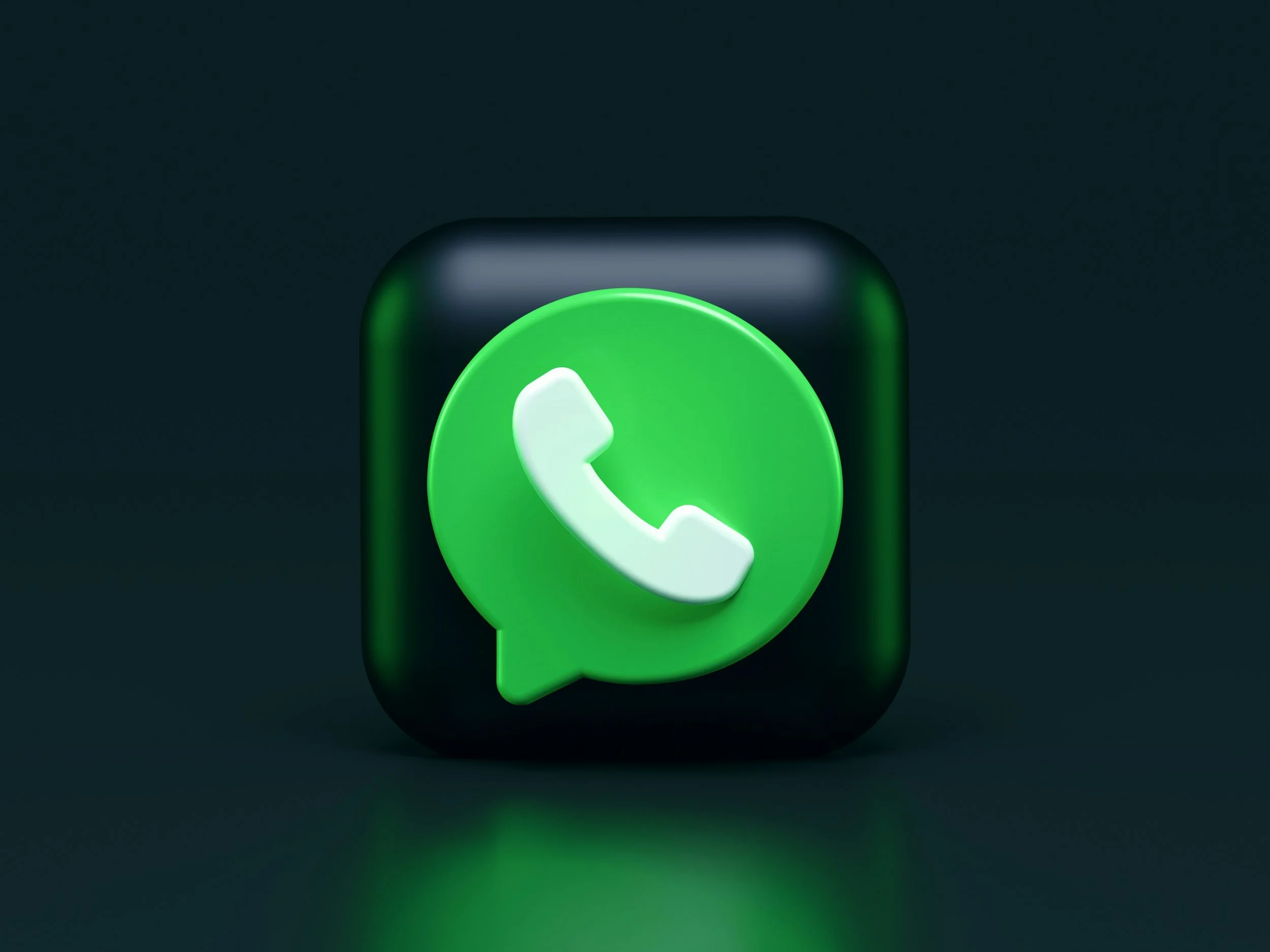 3D rendering of a black cube with a green WhatsApp logo on it, featuring a white speech bubble with a phone icon inside, set against a dark background.