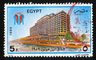circa-1989-stamp-printed-by-egypt-shows-nile-hilton-hotel-city-beach-sailboats-circa-1989.jpg