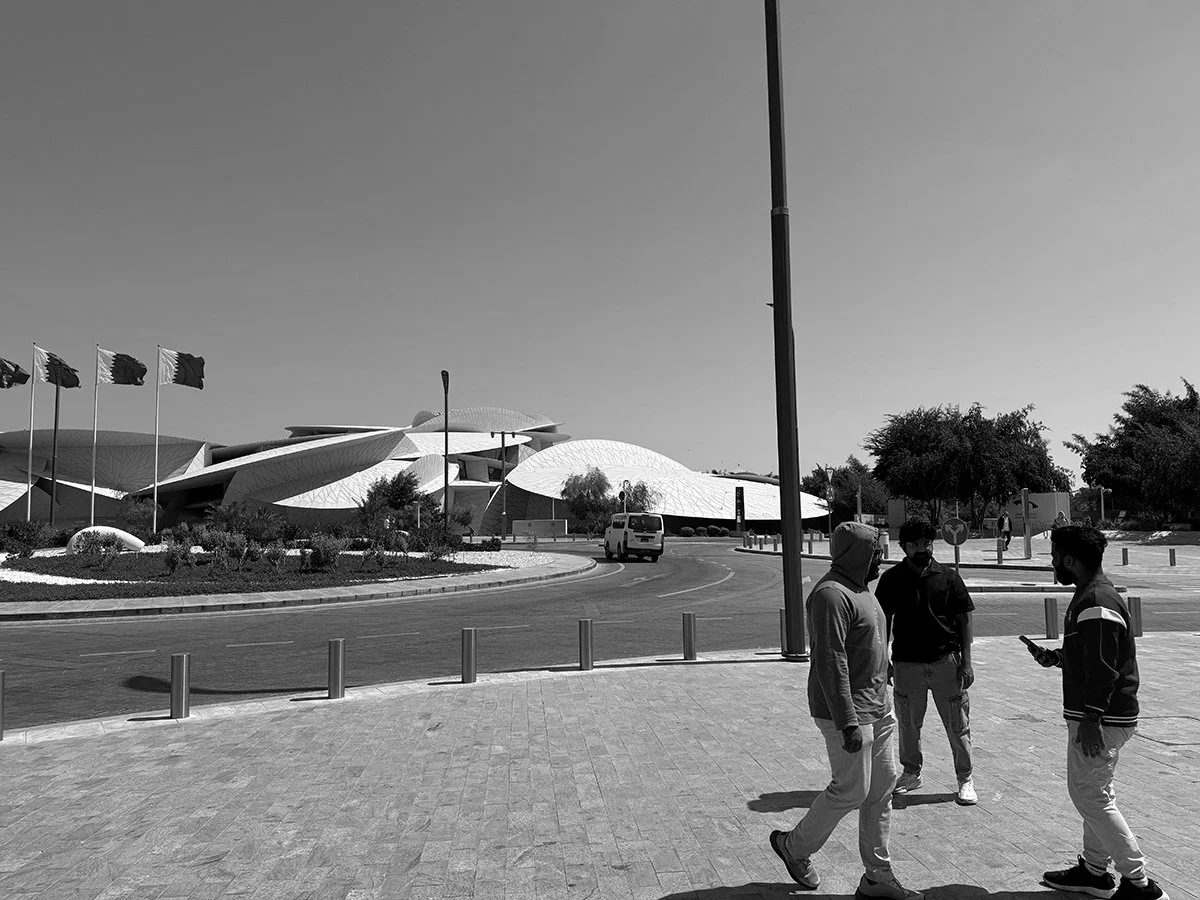 Migrant workers in front of the National Museum of Qatar. 2024