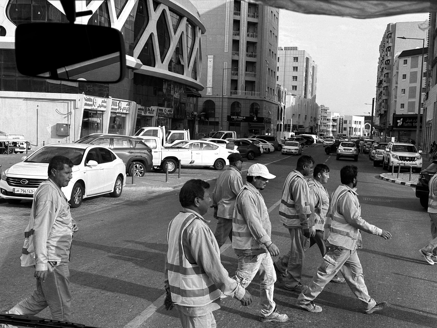 Laborers crossing a street in central Doha